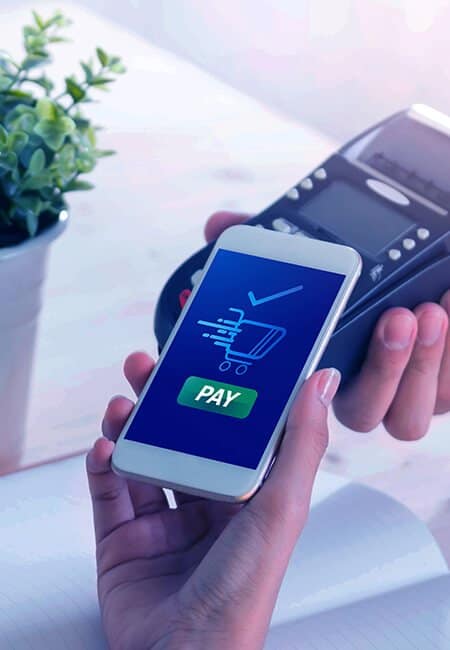 A woman holds out her phone to wirelessly pay for her purchase at the hand held point of sale system.